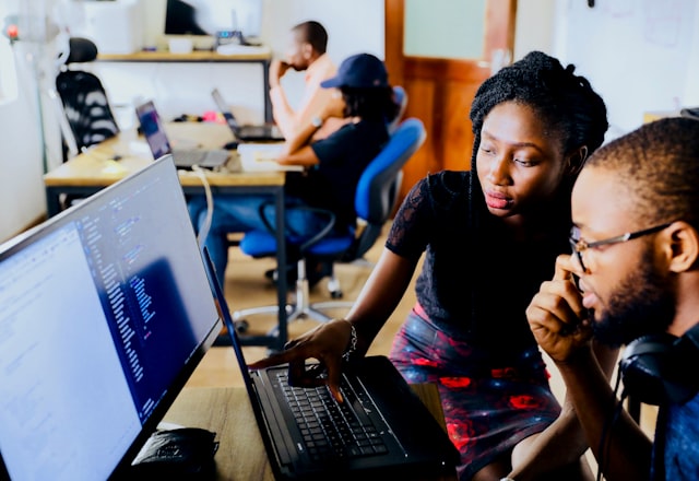 Two engineers reviewing code together during a team standup